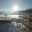 Schneebedecktes Gebäude und Landschaft bei sonnigem Wintertag mit Bergen im Hintergrund